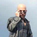 Looking over sunglasses The Shadow Priest looking over his sunglasses